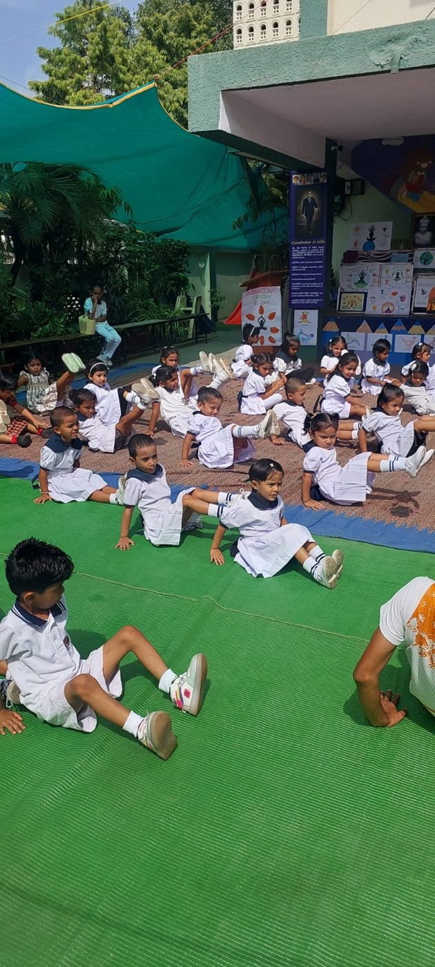 Pre-primary children practising yoga together on the school lawn